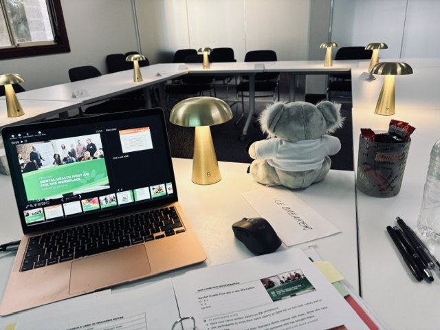 MHFA for the Workplace training room set up with laptop, koala mascot and lamps